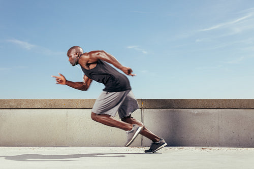 Action shot of a sporty young man running outdoors