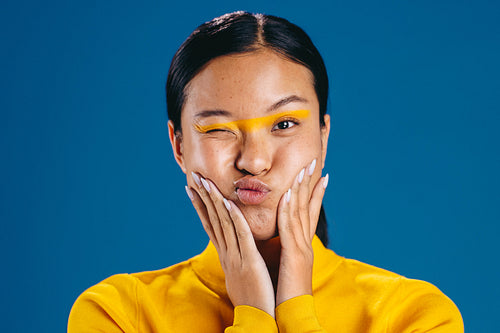 Portrait of a woman making a funny expression with a trendy makeup look, featuring graphic eye liner