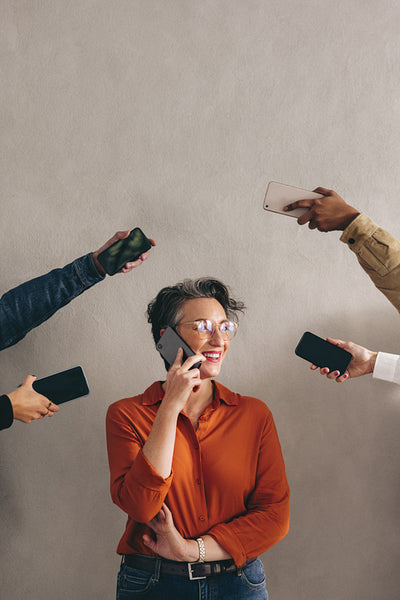 Happy businesswoman answering a phone call in a busy work environment