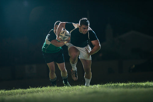 Rugby player running with ball for making score