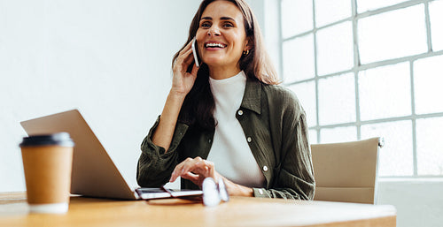 Successful business woman having a phone call conversation in an office