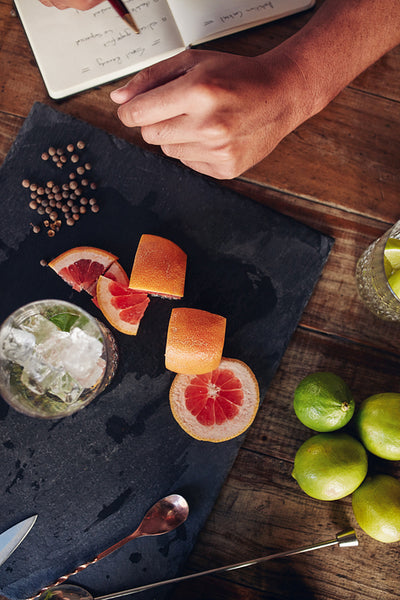 Ingredients for making a cocktail with bartender taking notes