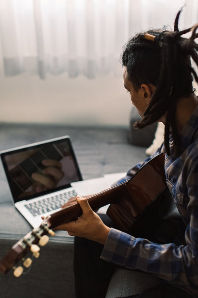 Young guitarist having online lessons during quarantine