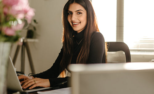Confident young businesswoman at her desk