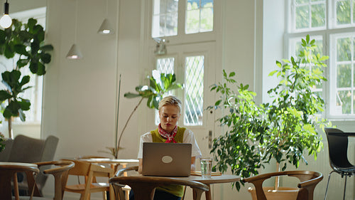 Women collaborate on a laptop during a business meeting in a bright coworking cafe