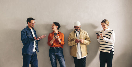 Happy businesspeople using their using their smartphones in a waiting area