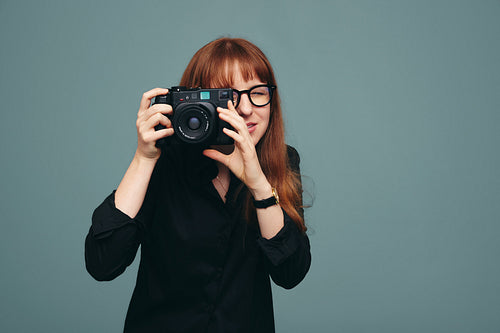 Skilful female photographer taking a picture on her digital came