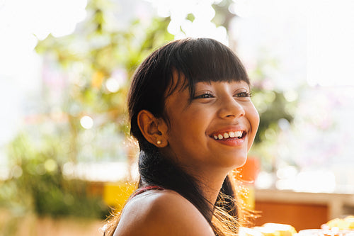 Smiling Latina girl outdoors in a bright and sunny environment