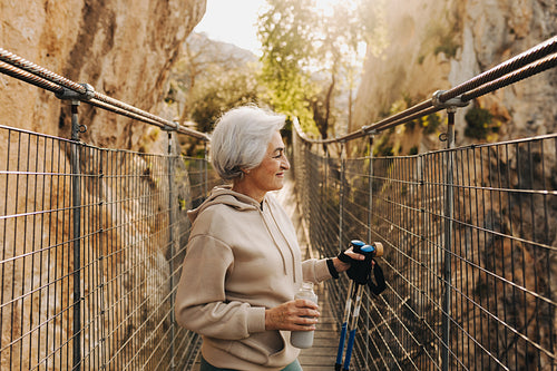 Cheerful senior woman going hiking outdoors