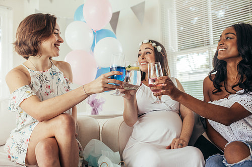 Friends celebrating baby shower with juices