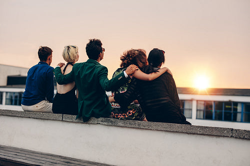 Friends relaxing on terrace in evening