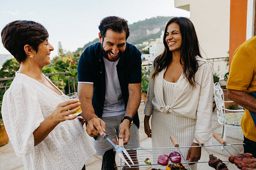 Friends enjoying a Brazilian churrasco barbecue on a sunny patio