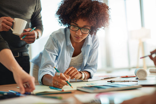 Creative woman working in office with colleagues
