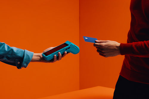 Cashback and payment in retail with a wireless card reader in a colorful studio shot