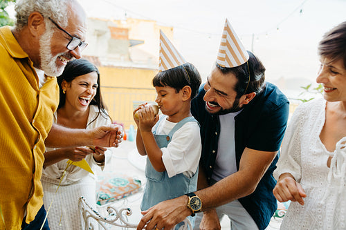 Family celebration with laughter and fun outdoors wearing party hats