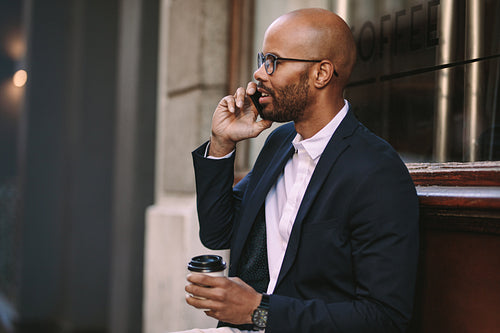Businessman relaxing outdoors making a phone call