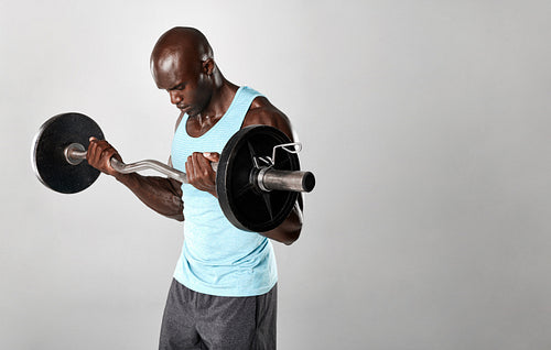 Young african man working out with barbell
