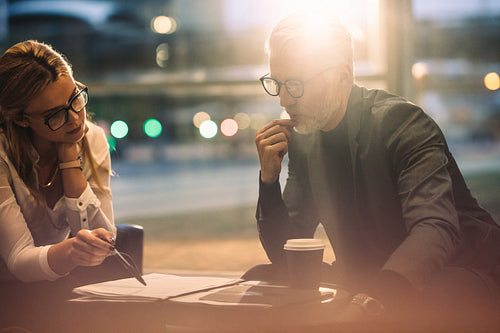 Businesspeople discussing over contract documents