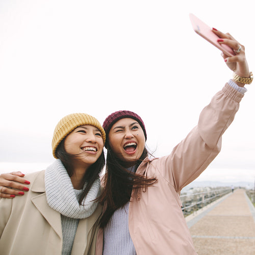 Cheerful women friends having fun standing outdoors