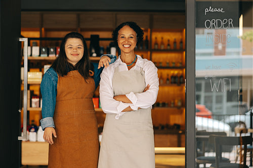 Happy store employees standing in front of their grocery store