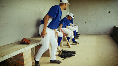 Baseball players watch from the dugout