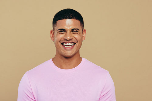 Portrait of a young man smiling at the camera, showing his radiant and youthful skin