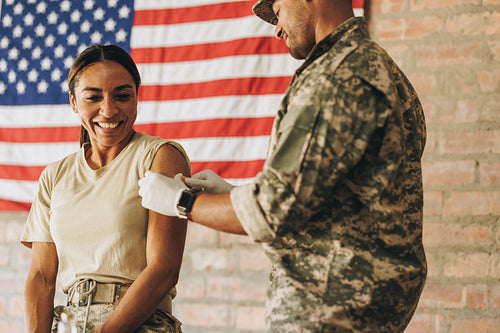 Cheerful servicewoman smiling happily after getting vaccinated