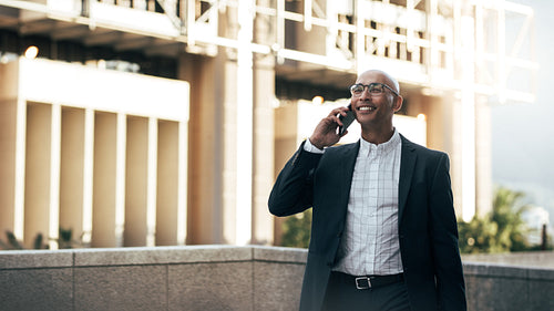 Businessman talking over mobile phone standing outdoors