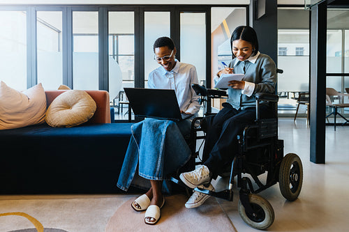 Diverse coworkers collaborating on a laptop in a modern office setting
