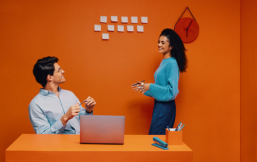 Creative marketing meeting with co-workers discussing strategies in a vibrant office setting