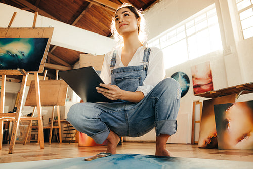 Self-employed painter looking thoughtful in her art studio