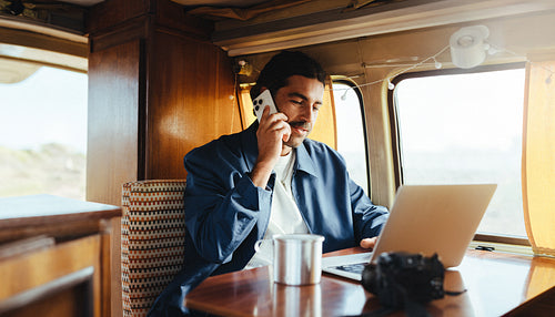 On-the-road call: Man talks on the phone inside his camper van