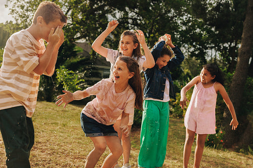Children playing outdoors with joy and laughter on a summer day