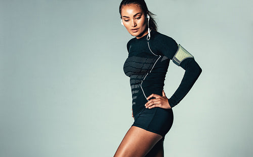 Fitness woman listening to music with earphones