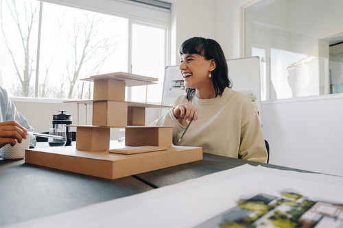Female manager discussing architecture model in a modern office