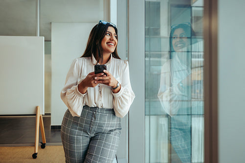 Confident professional woman wearing stylish clothing in a modern office setting