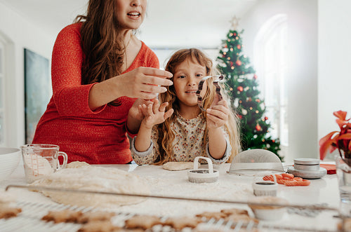 Mother and daughter preparing Christmas cookies.