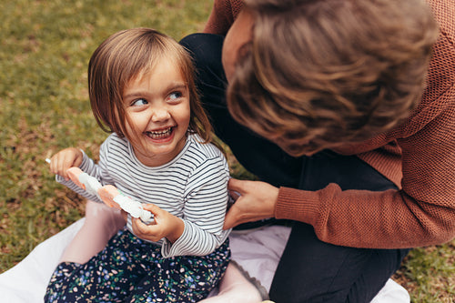 Little girl with her father outdoors holding a candy