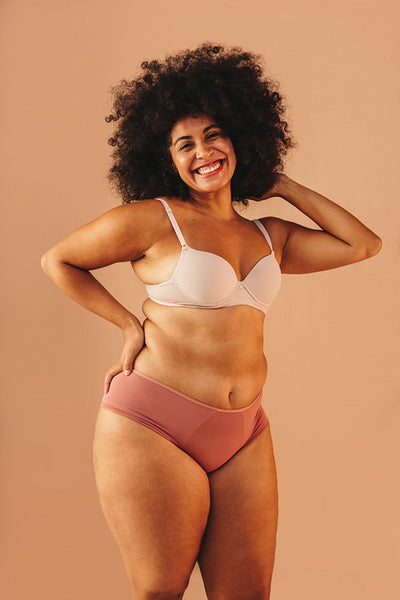 Beautiful plus-size woman smiling happily in underwear
