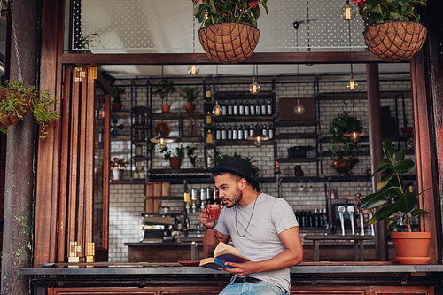 Young man drinking coffee and reading book