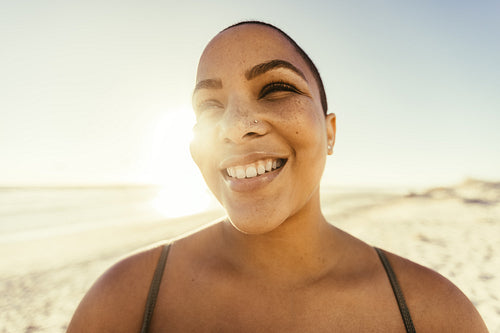 Carefree young woman smiling at the beach