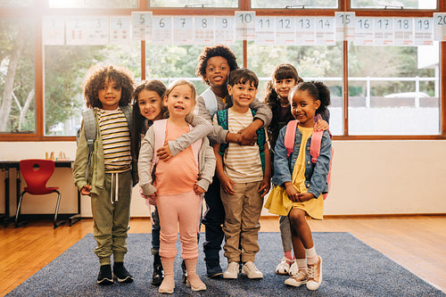 Group of elementary school students standing together in a classroom