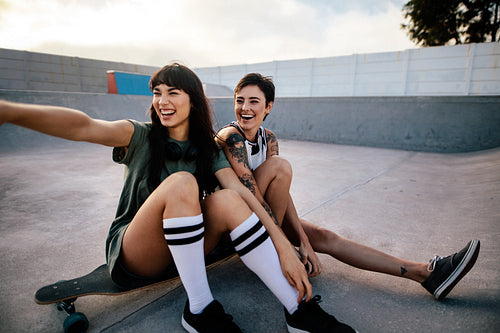 Smiling female skaters hanging out at skate park