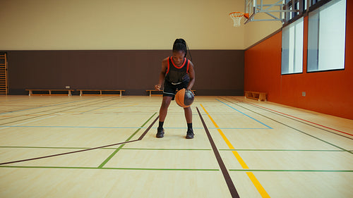 Young athlete dribbles basketball on court