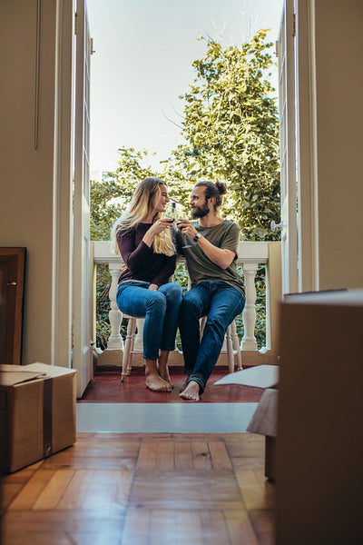 Couple sitting in balcony toasting their glasses on wine