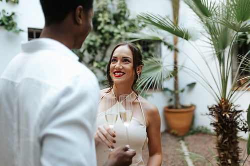 Romantic couple making a toast with sparkling wine in their backyard