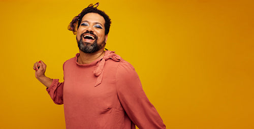 Genderqueer smiling on yellow background