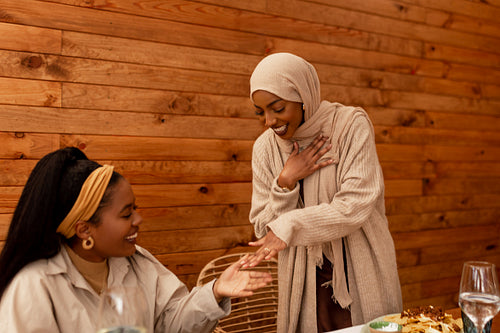 Modest muslim woman showing her engagement ring to her friend in
