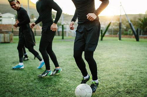Teenagers practicing football on field