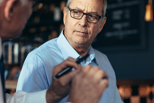 Businessmen discussing issues in cafe